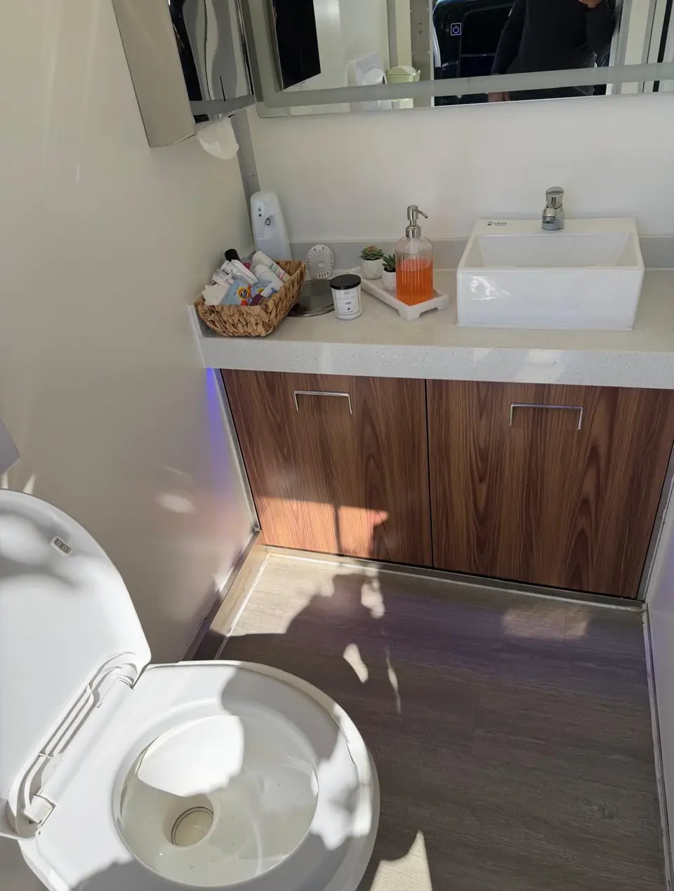 Restroom trailer with a wood vanity, sink and toiletries